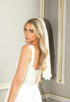 Woman wearing a white wedding dress with a veil in an elegant room.