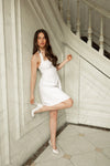 Woman in a white dress standing in a staircase